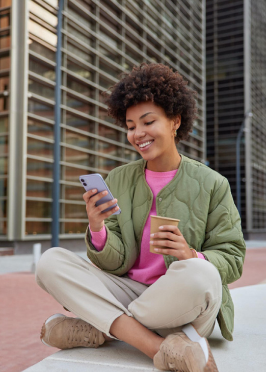 A woman using the T Bank mobile banking app on her phone to manage her Houston checking account.